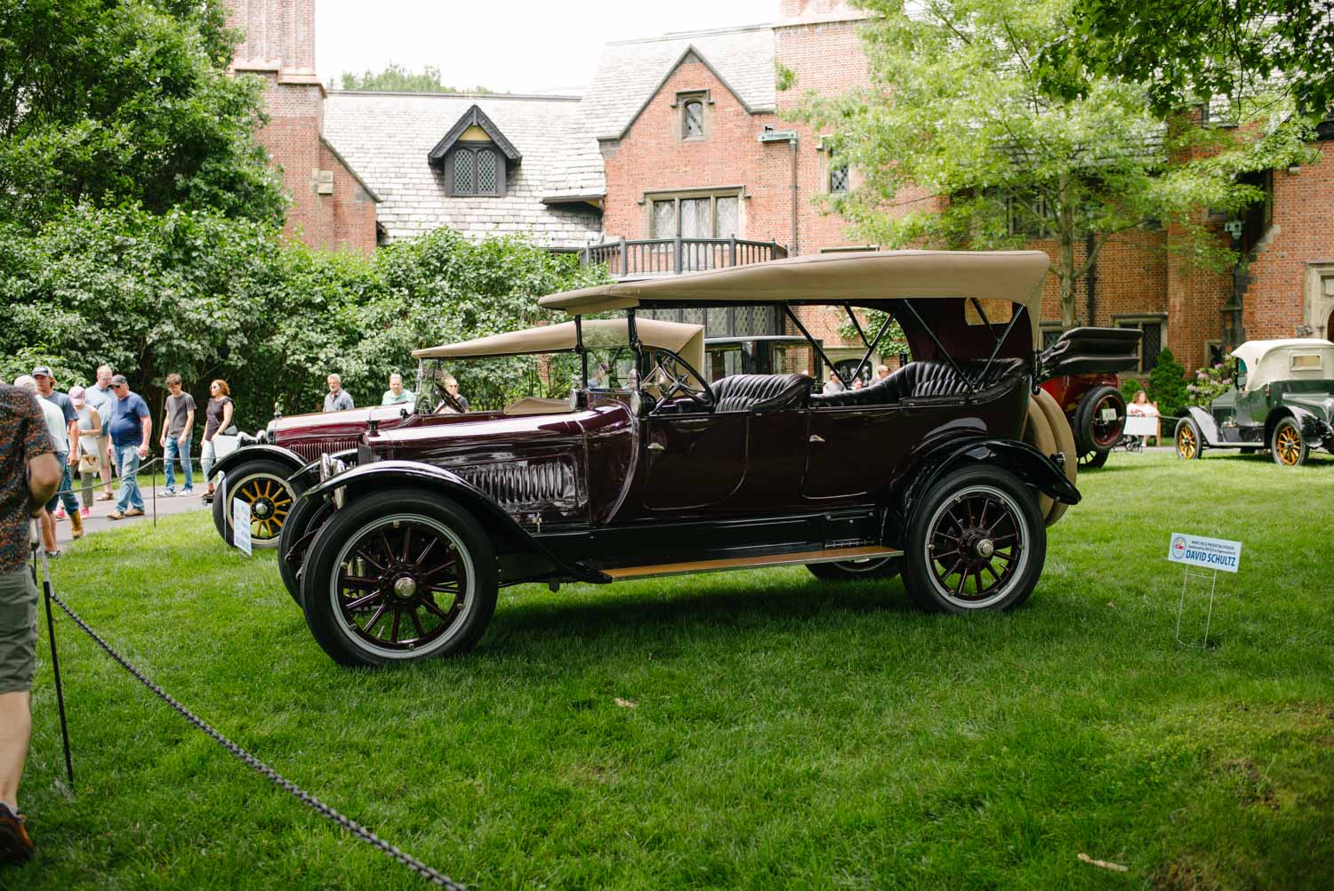 Deep Burgundy Touring Car in Front of Mansion